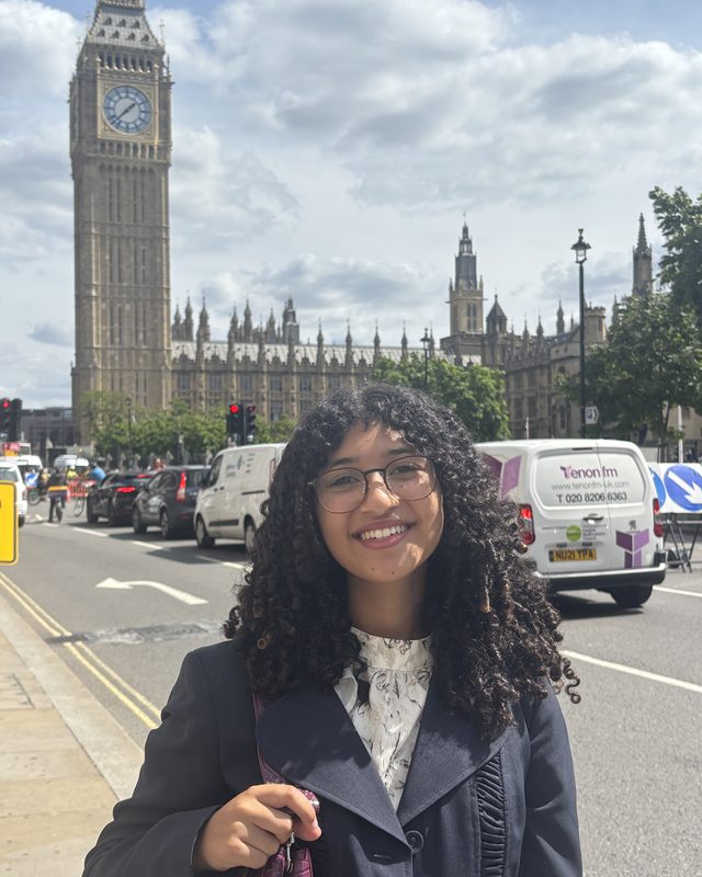 Gracie Plonisch standing in front of the Houses of Parliament and Big Ben in London